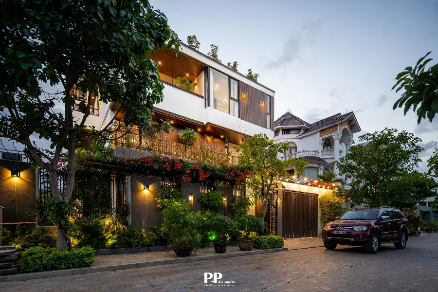 Cách chọn vật liệu xanh trong thiết kế villa bền vững, sang trọng 2026 6 Mặt tiền villa xanh với cây xanh, ánh sáng ấm và vật liệu ngoại thất bền đẹp